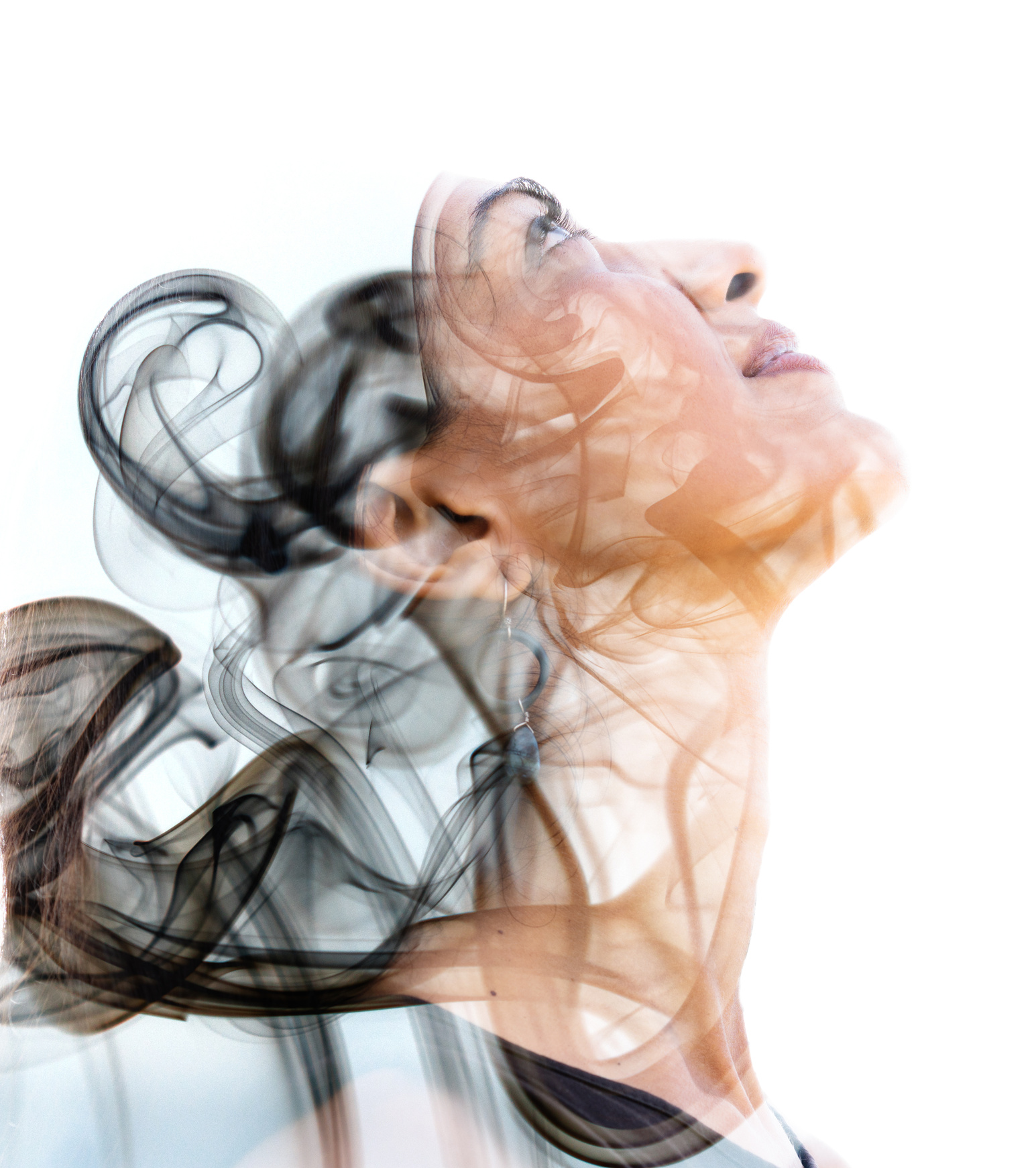 Double exposure portrait of a young exotic woman and a smoky texture dissolving into her facial features